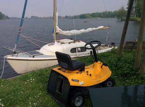 The lawn mower at the sailclub standing next to my boat, which is moored to the waterside
