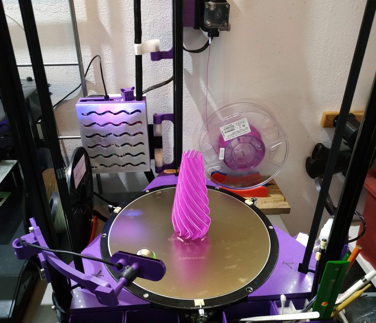 a picture of my delta printer with a bright colored vase on the printbed